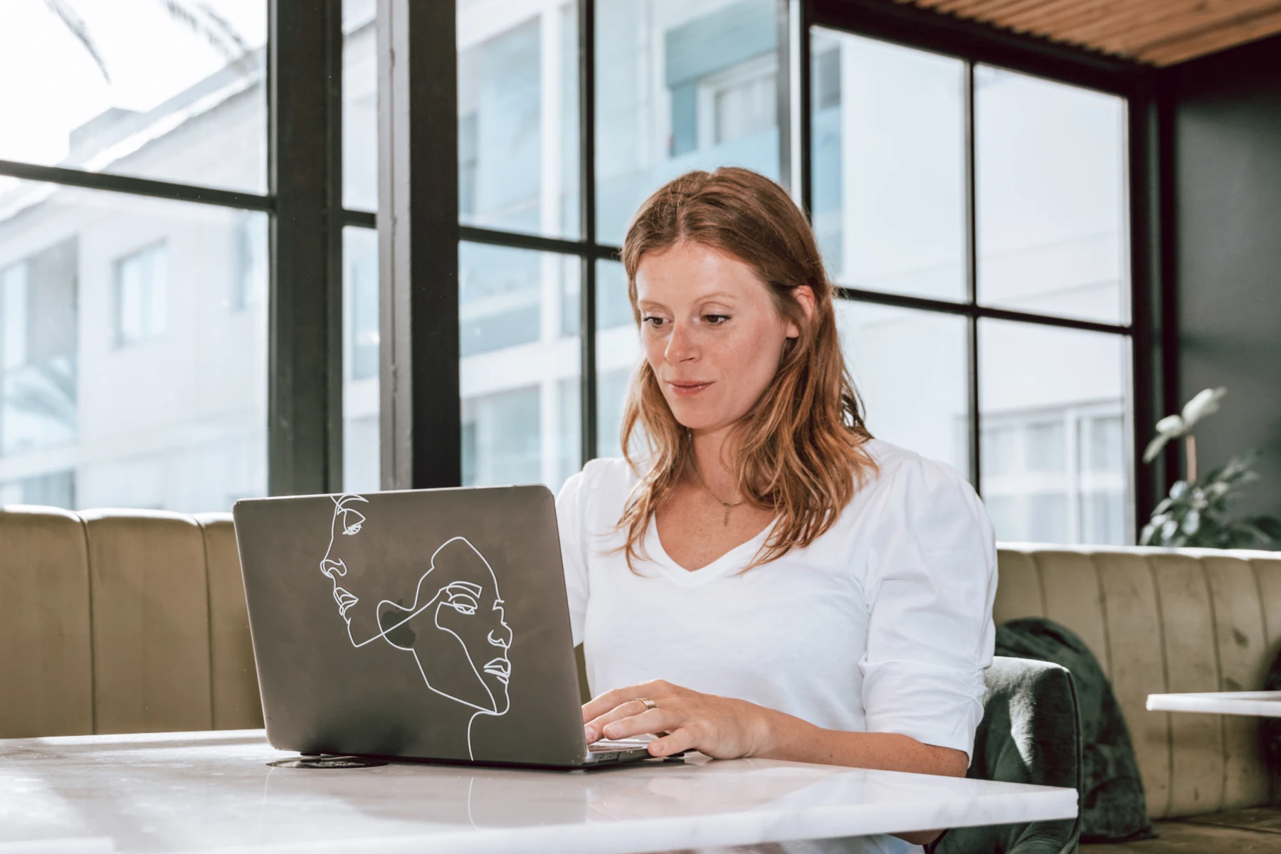 Farina Schurzfeld arbeitet an einem Laptop am Fenster