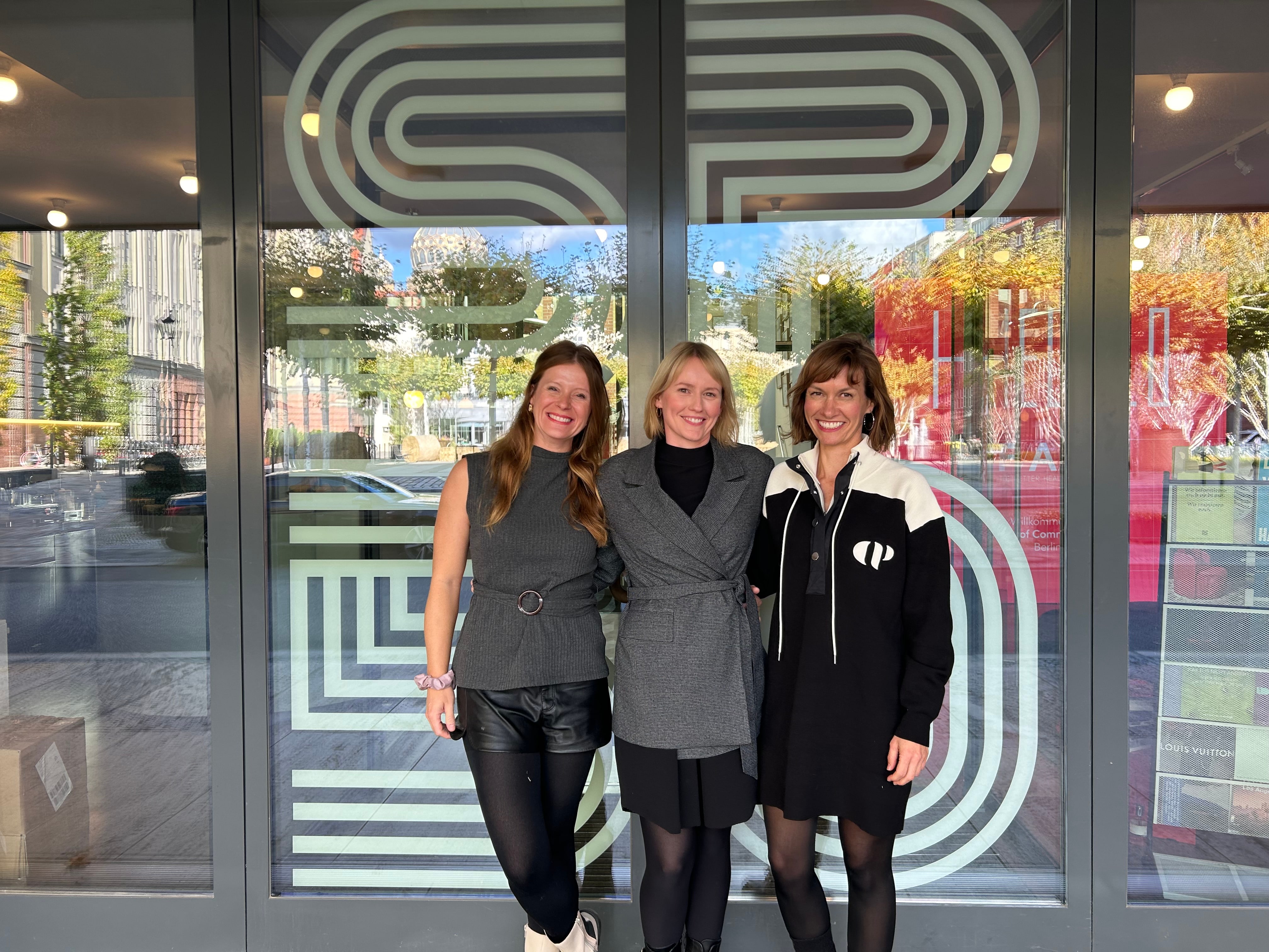 Three team members in front of a storefront with andRobin branding