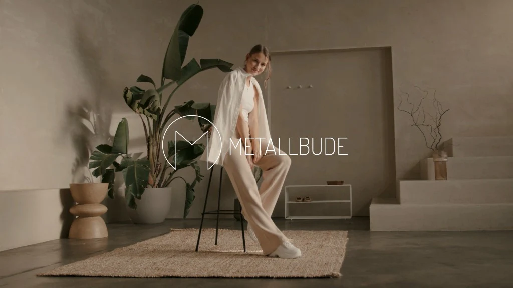 Woman in minimalist interior with Metallbude branding